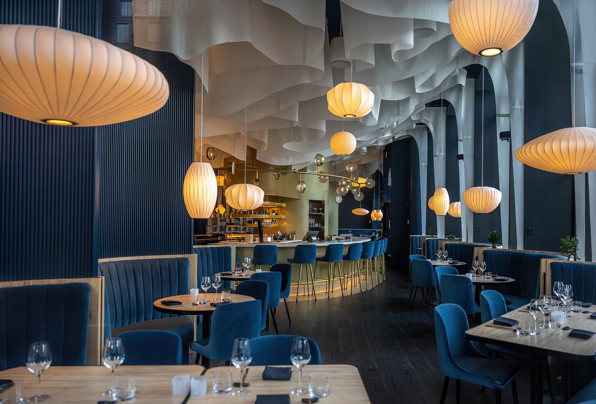 Interior cálido de un restaurante con mesas preparadas